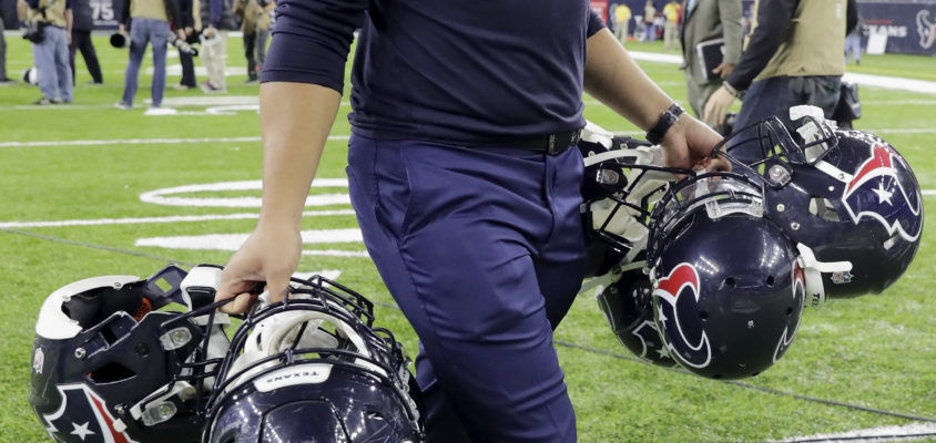 HOUSTON, TX - JANUARY 07: A Houston Texans equipment manager carries helmets after the game against the Oakland Raiders at NRG Stadium on January 7, 2017 in Houston, Texas.