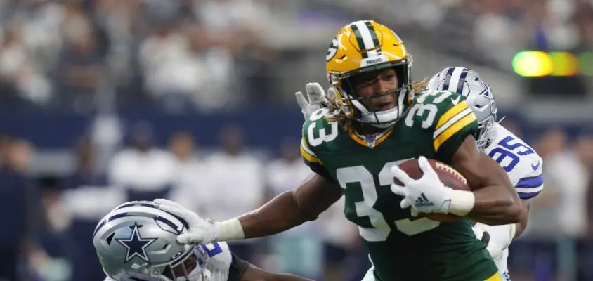 ARLINGTON, TEXAS - OCTOBER 06: Aaron Jones #33 of the Green Bay Packers stiff-arms Xavier Woods #25 of the Dallas Cowboys on a run in the first quarter at AT&T Stadium on October 06, 2019 in Arlington, Texas