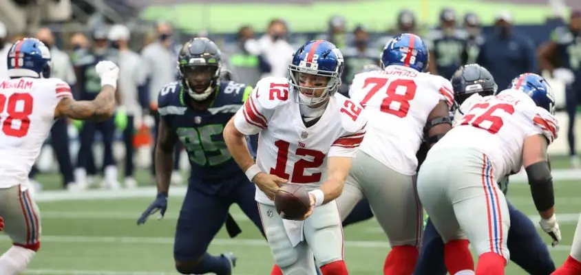 SEATTLE, WASHINGTON - DECEMBER 06: Colt McCoy #12 of the New York Giants looks to hand the ball off in the second quarter against the Seattle Seahawks at Lumen Field on December 06, 2020 in Seattle, Washington