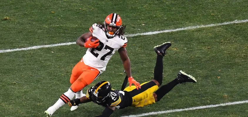 PITTSBURGH, PENNSYLVANIA - JANUARY 10: Kareem Hunt #27 of the Cleveland Browns avoids a tackle by Cameron Sutton #20 of the Pittsburgh Steelers during the second half of the AFC Wild Card Playoff game at Heinz Field on January 10, 2021 in Pittsburgh, Pennsylvania