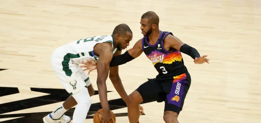 PHOENIX, ARIZONA - FEBRUARY 10: Khris Middleton #22 of the Milwaukee Bucks handles the ball against Chris Paul #3 of the Phoenix Suns during the NBA game at Phoenix Suns Arena on February 10, 2021 in Phoenix, Arizona. The Suns defeated the Bucks 125-124.