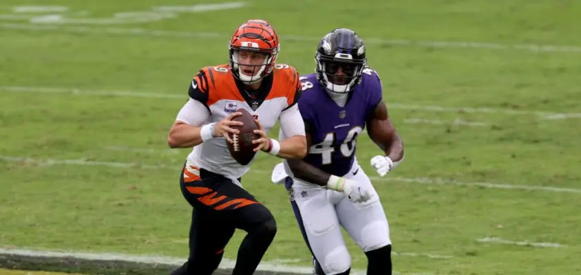 BALTIMORE, MARYLAND - OCTOBER 11: Quarterback Joe Burrow #9 of the Cincinnati Bengals is chased by inside linebacker Patrick Queen #48 of the Baltimore Ravens in the first half at M&T Bank Stadium on October 11, 2020 in Baltimore, Maryland