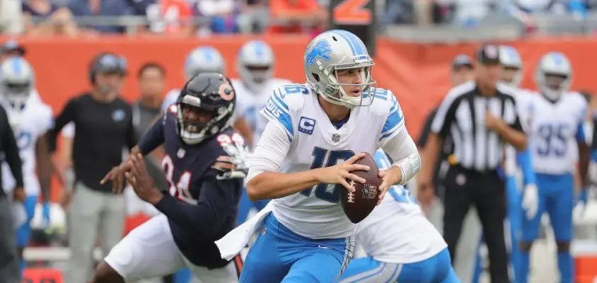 CHICAGO, ILLINOIS - OCTOBER 03: Jared Goff #16 of the Detroit Lions rolls out to look for a receiver as Robert Quinn #94 of the Chicago Bears rushes behind him at Soldier Field on October 03, 2021 in Chicago, Illinois. The Bears defeated the Lions 24-14