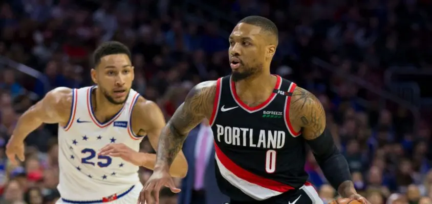 PHILADELPHIA, PA - FEBRUARY 23: Damian Lillard #0 of the Portland Trail Blazers dribbles the ball against Ben Simmons #25 of the Philadelphia 76ers in the first quarter at the Wells Fargo Center on February 23, 2019 in Philadelphia, Pennsylvania