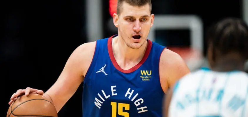 CHARLOTTE, NORTH CAROLINA - MARCH 28: Nikola Jokic #15 of the Denver Nuggets brings the ball up court while guarded by Terry Rozier #3 of the Charlotte Hornets in the fourth quarter at Spectrum Center on March 28, 2022 in Charlotte, North Carolina