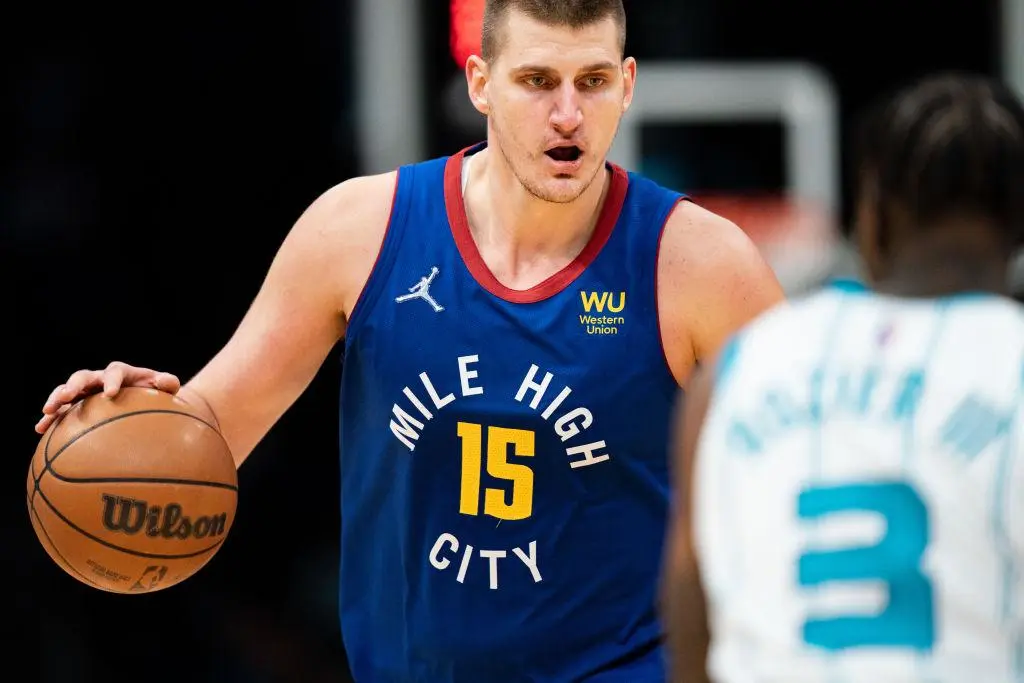 CHARLOTTE, NORTH CAROLINA - MARCH 28: Nikola Jokic #15 of the Denver Nuggets brings the ball up court while guarded by Terry Rozier #3 of the Charlotte Hornets in the fourth quarter at Spectrum Center on March 28, 2022 in Charlotte, North Carolina