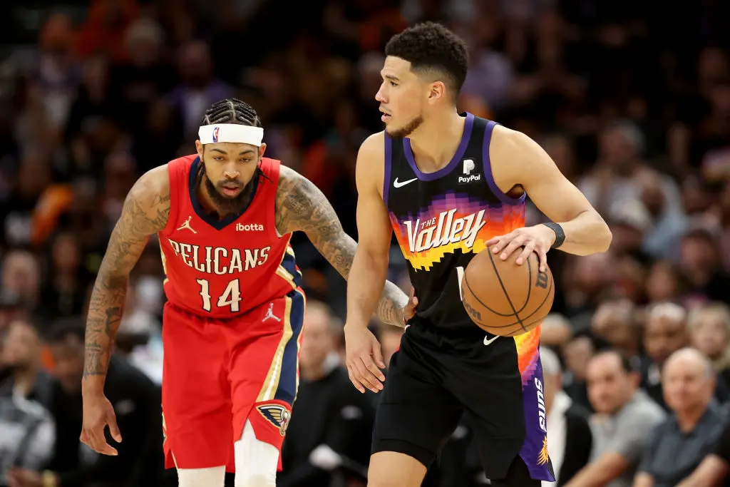 PHOENIX, ARIZONA - APRIL 17: Devin Booker #1 of the Phoenix Suns handles the ball against Brandon Ingram #14 of the New Orleans Pelicans during the second half of Game One of the Western Conference First Round NBA Playoffs at Footprint Center on April 17, 2022 in Phoenix, Arizona. The Suns defeated the Pelicans 110-109.