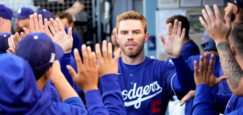 Los Angeles, CA - April 05: Freddie Freeman #5 of the Los Angeles Dodgers high fives teammates after scoring on a RBI double by teammate Trea Turner (not pictured) Dodgers against the Los Angeles Angels in the first inning of a spring training baseball game at Dodger Stadium in Los Angeles on Tuesday, April 5, 2022