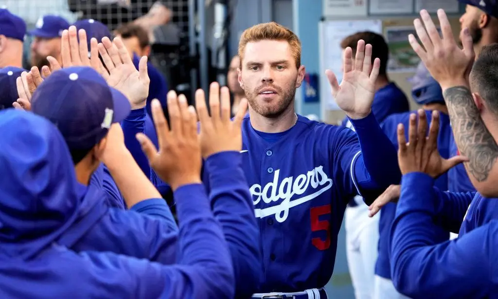 Los Angeles, CA - April 05: Freddie Freeman #5 of the Los Angeles Dodgers high fives teammates after scoring on a RBI double by teammate Trea Turner (not pictured) Dodgers against the Los Angeles Angels in the first inning of a spring training baseball game at Dodger Stadium in Los Angeles on Tuesday, April 5, 2022