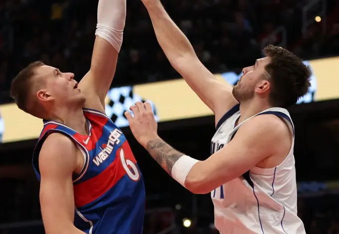 WASHINGTON, DC - APRIL 01: Kristaps Porzingis #6 of the Washington Wizards shoots in front of Luka Doncic #77 of the Dallas Mavericks during the second half at Capital One Arena on April 01, 2022 in Washington, DC.