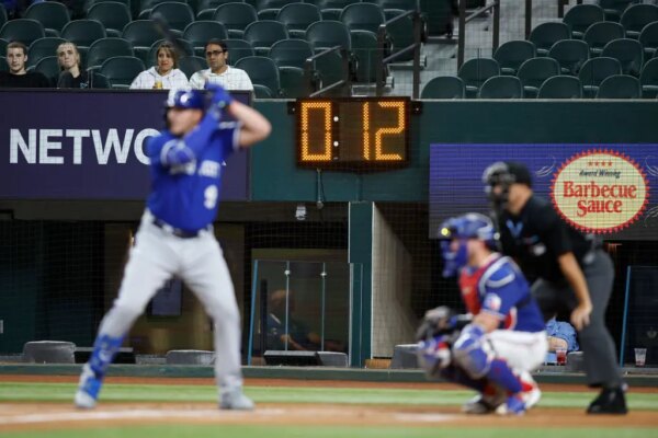 ARLINGTON, TEXAS - MARCH 27: Vinnie Pasquantino #9 of the Kansas City Royals bats with a pitch clock in the background in the first inning against the Texas Rangers at Globe Life Field on March 27, 2023 in Arlington, Texas