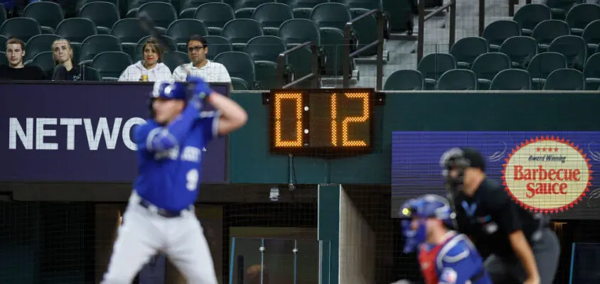 ARLINGTON, TEXAS - MARCH 27: Vinnie Pasquantino #9 of the Kansas City Royals bats with a pitch clock in the background in the first inning against the Texas Rangers at Globe Life Field on March 27, 2023 in Arlington, Texas