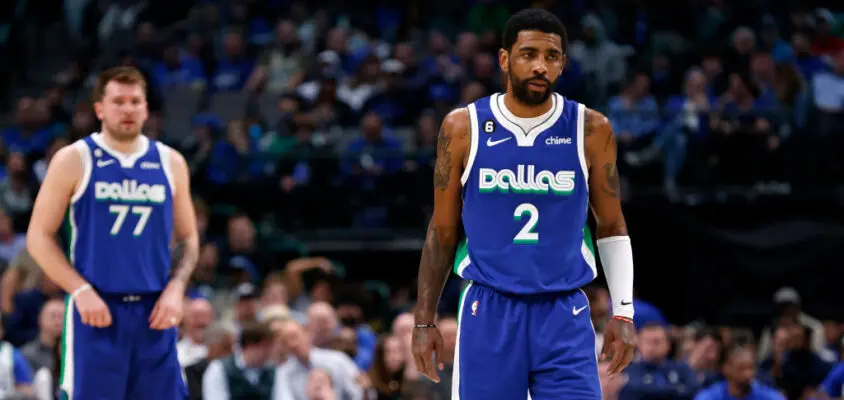 DALLAS, TX - FEBRUARY 13: Kyrie Irving #2 of the Dallas Mavericks and teammate Luka Doncic #77 look on as the Mavericks play the Minnesota Timberwolves in the second half at American Airlines Center on February 13, 2023 in Dallas, Texas.