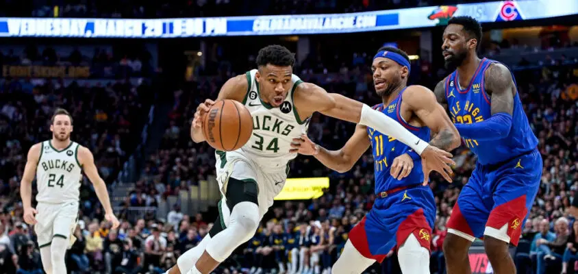 DENVER, CO - MARCH 25: Giannis Antetokounmpo #34 of the Milwaukee Bucks dribbles past Bruce Brown #11 and Jeff Green #32 of the Denver Nuggets in the second half of a game at Ball Arena on March 25, 2023 in Denver, Colorado.