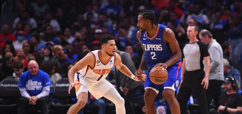 LOS ANGELES, CA - OCTOBER 23: Los Angeles Clippers forward Kawhi Leonard (2) guarded by Phoenix Suns guard Devin Booker (1) during a NBA game between the Phoenix Suns and the Los Angeles Clippers on October 23, 2022 at Crypto.com Arena in Los Angeles, CA.