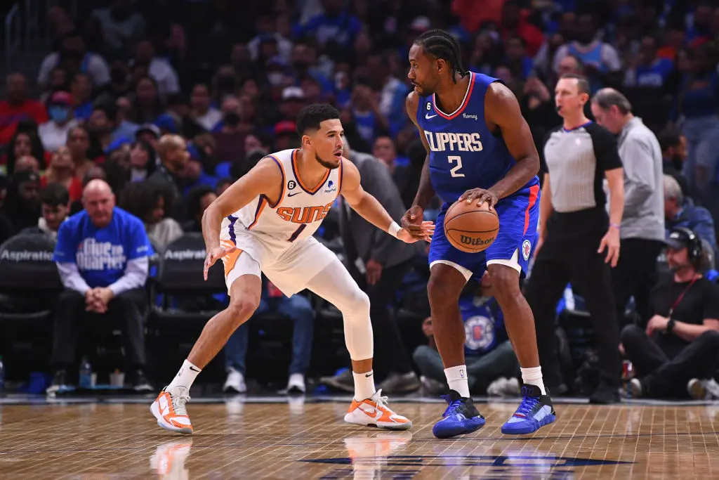 LOS ANGELES, CA - OCTOBER 23: Los Angeles Clippers forward Kawhi Leonard (2) guarded by Phoenix Suns guard Devin Booker (1) during a NBA game between the Phoenix Suns and the Los Angeles Clippers on October 23, 2022 at Crypto.com Arena in Los Angeles, CA.