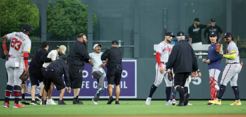 DENVER, COLORADO - AUGUST 28: A fan yells to Ronald Acuna Jr. #13 of the Atlanta Braves after running on the field and being apprehended by security during the game between the Colorado Rockies and the Atlanta Braves at Coors Field on August 28, 2023 in Denver, Colorado