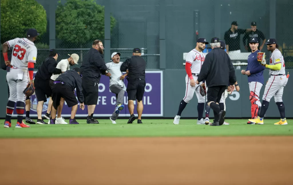 DENVER, COLORADO - AUGUST 28: A fan yells to Ronald Acuna Jr. #13 of the Atlanta Braves after running on the field and being apprehended by security during the game between the Colorado Rockies and the Atlanta Braves at Coors Field on August 28, 2023 in Denver, Colorado