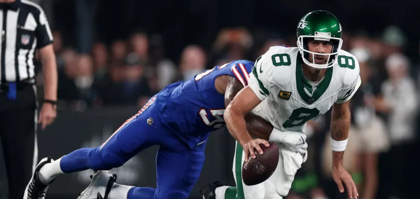 EAST RUTHERFORD, NEW JERSEY - SEPTEMBER 11: Quarterback Aaron Rodgers #8 of the New York Jets sacked by defensive end Leonard Floyd #56 of the Buffalo Bills during the first quarter of the NFL game at MetLife Stadium on September 11, 2023 in East Rutherford, New Jersey