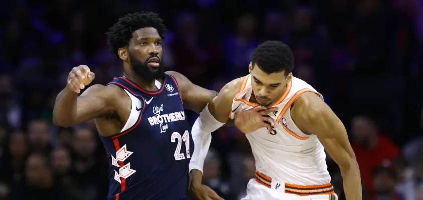 PHILADELPHIA, PENNSYLVANIA - JANUARY 22: Joel Embiid #21 of the Philadelphia 76ers and Victor Wembanyama #1 of the San Antonio Spurs jostle during the first quarter at the Wells Fargo Center on January 22, 2024 in Philadelphia, Pennsylvania.