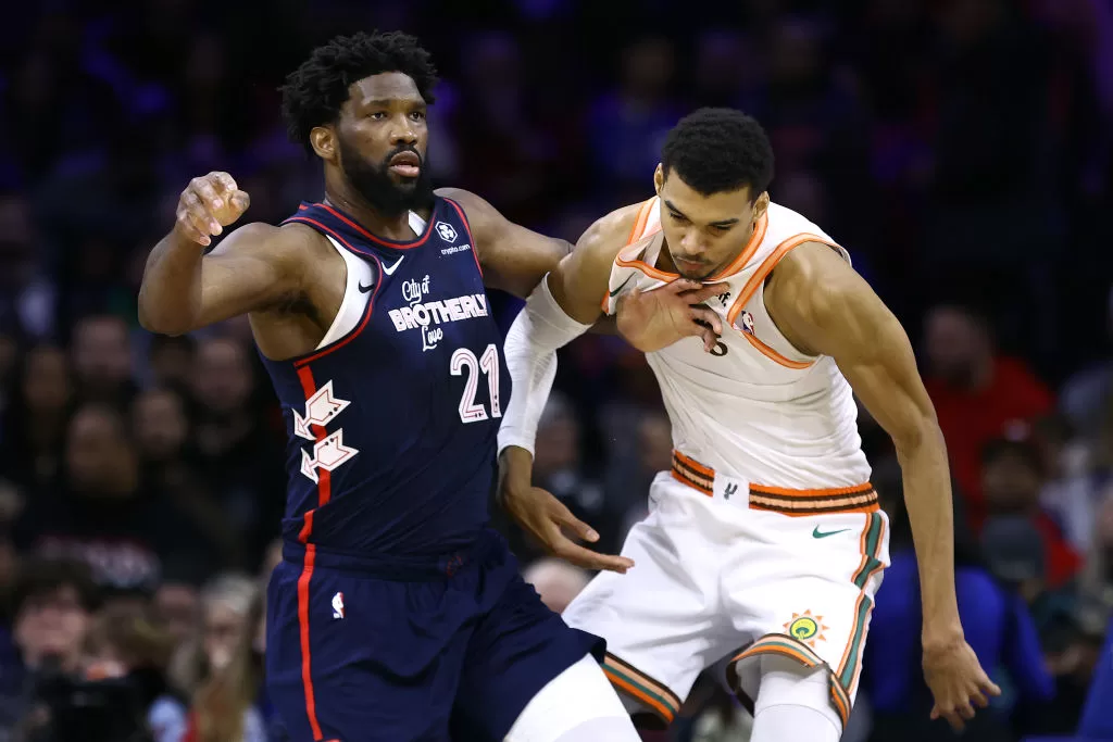 PHILADELPHIA, PENNSYLVANIA - JANUARY 22: Joel Embiid #21 of the Philadelphia 76ers and Victor Wembanyama #1 of the San Antonio Spurs jostle during the first quarter at the Wells Fargo Center on January 22, 2024 in Philadelphia, Pennsylvania.