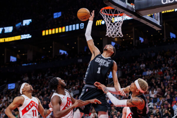 TORONTO, CANADA - FEBRUARY 12: Victor Wembanyama #1 of the San Antonio Spurs grabs a rebound from Bruce Brown #11 and Immanuel Quickley #5 of the Toronto Raptors in the second half of their NBA game at Scotiabank Arena on February 12, 2024 in Toronto, Canada.