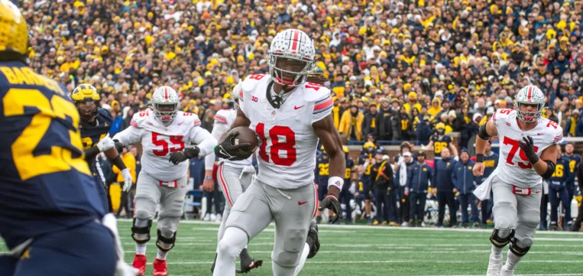 ANN ARBOR, MICHIGAN - NOVEMBER 25: Marvin Harrison Jr. #18 of the Ohio State Buckeyes runs with the ball for a touchdown during the second half of a college football game against the Michigan Wolverines at Michigan Stadium on November 25, 2023 in Ann Arbor, Michigan. The Michigan Wolverines won the game 30-24 to win the Big Ten East.