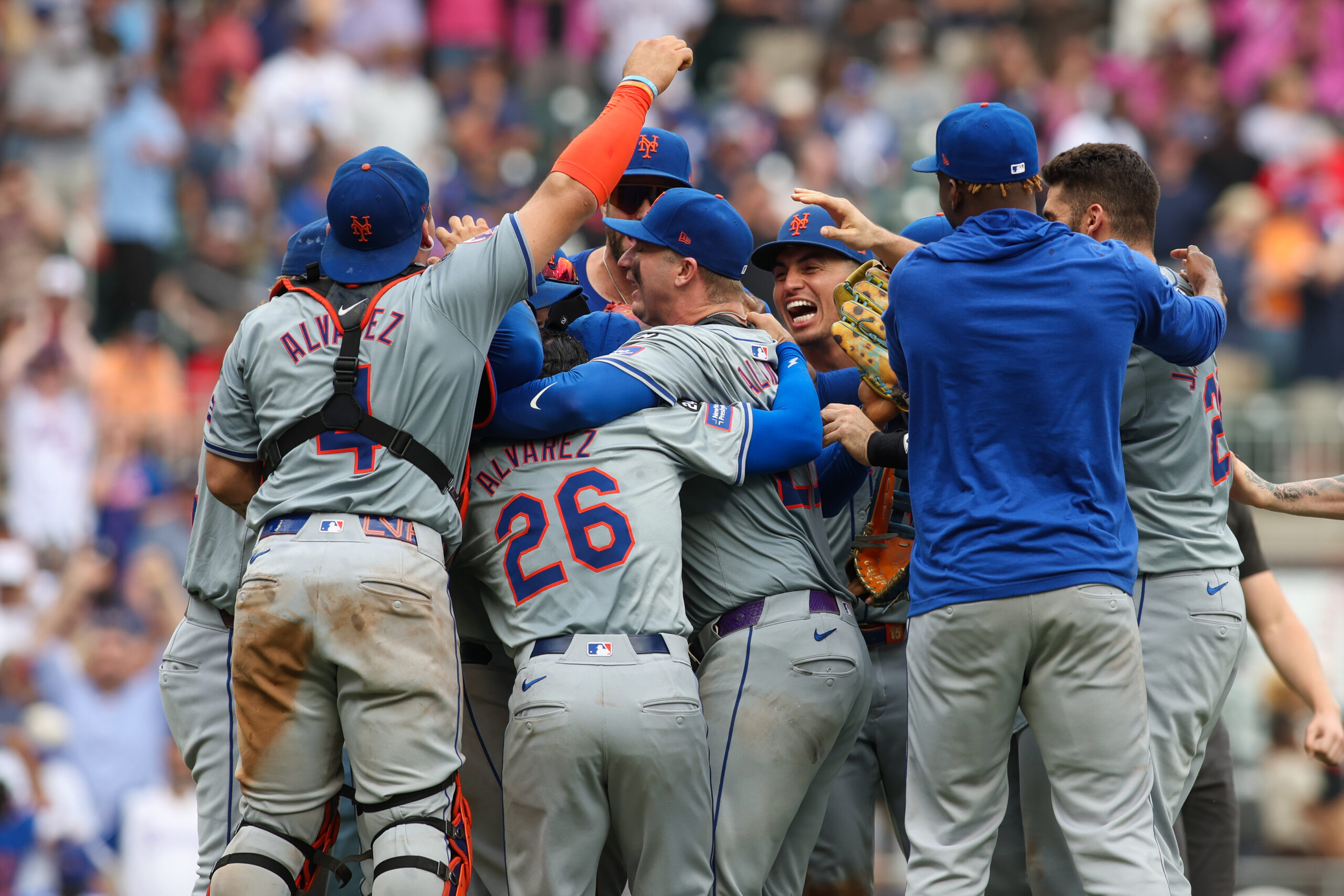 Sep 30, 2024; Atlanta, Georgia, USA; New York Mets catcher Francisco Alvarez (4) and second baseman Eddy Alvarez (26) and first baseman Pete Alonso (20) celebrate after a victory over the Atlanta Braves that clinched a wild card playoff birth at Truist Park