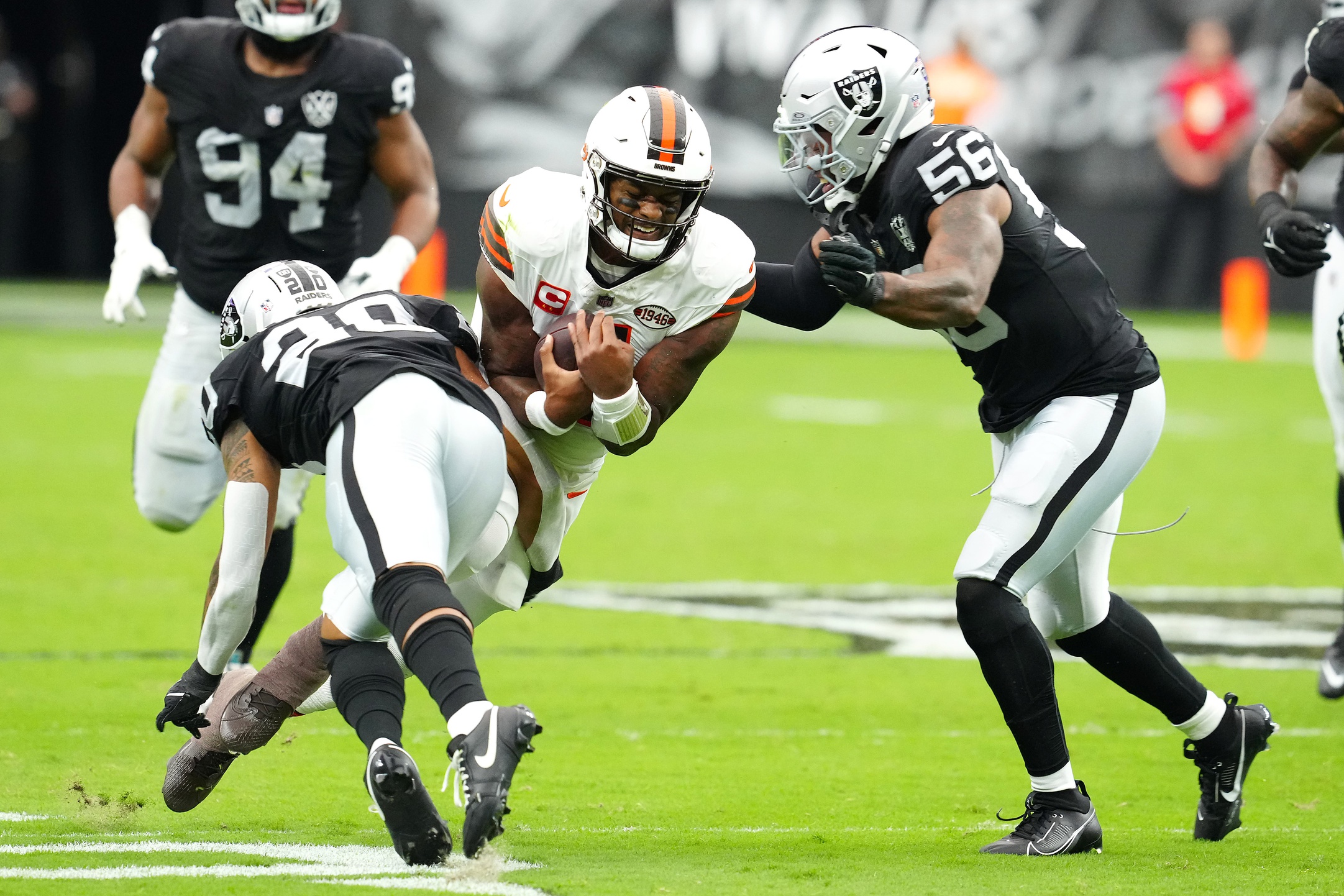 Sep 29, 2024; Paradise, Nevada, USA; Cleveland Browns quarterback Deshaun Watson (4) braces for the tackles of Las Vegas Raiders safety Isaiah Pola-Mao (20) and Las Vegas Raiders linebacker Amari Burney (56) during the first quarter at Allegiant Stadium.