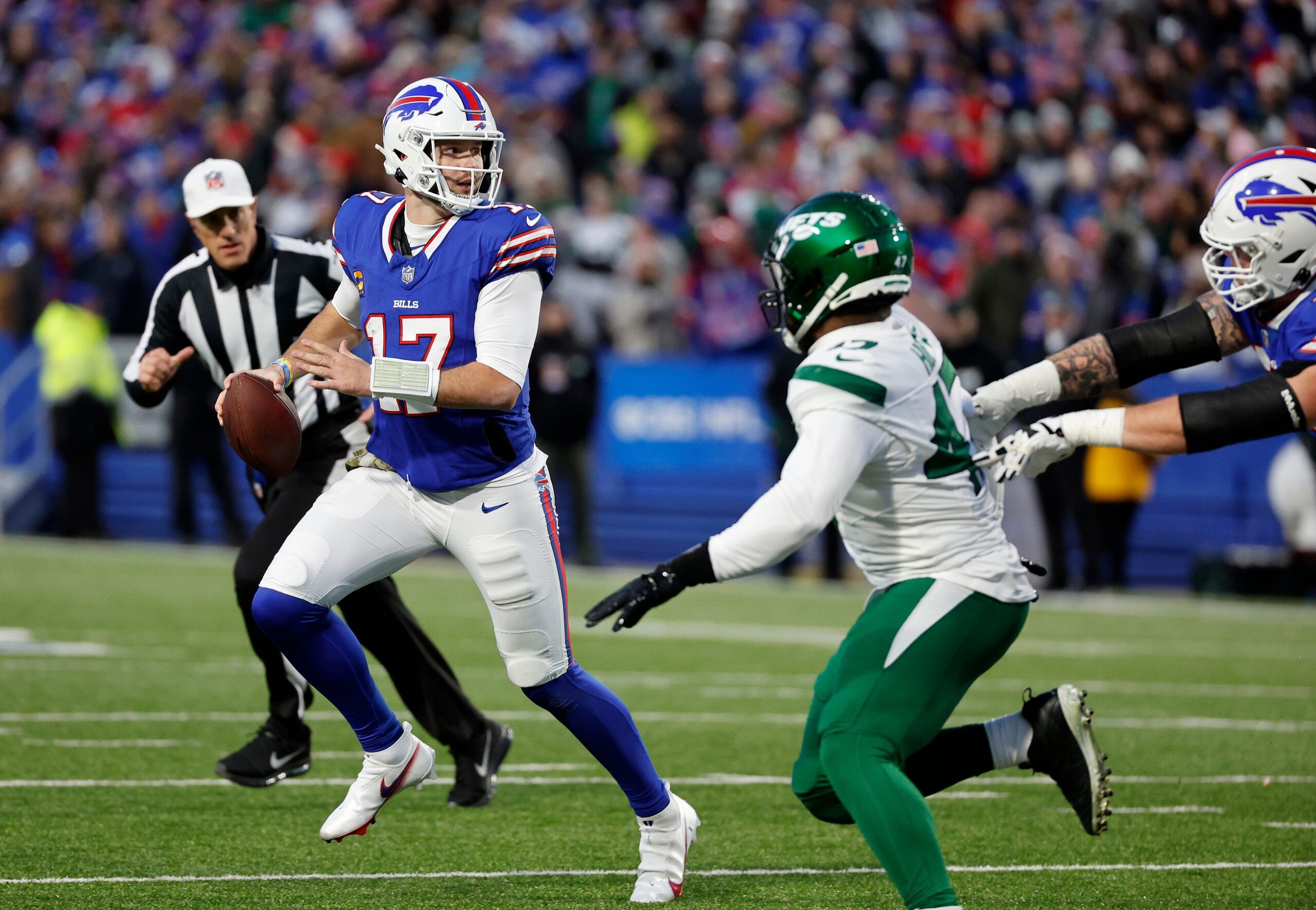 Buffalo Bills quarterback Josh Allen (17) rolls away from pressure against the Jets.