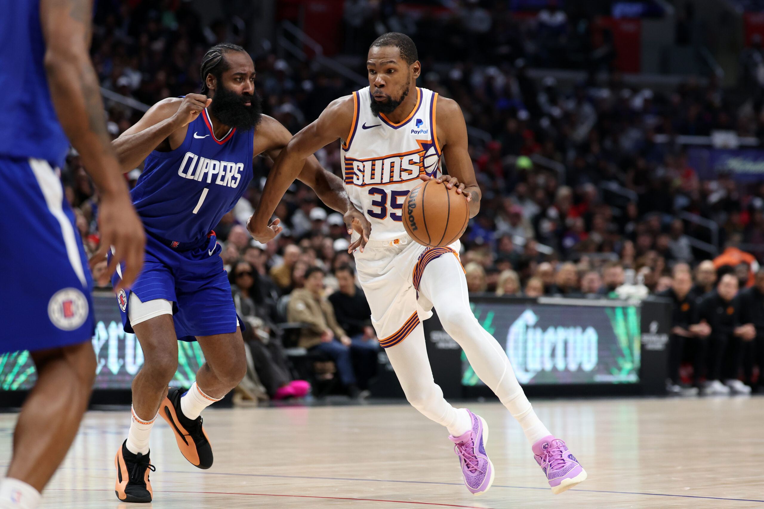 Jan 8, 2024; Los Angeles, California, USA; NBA; Phoenix Suns forward Kevin Durant (35) dribbles the ball against Los Angeles Clippers guard James Harden (1) during the fourth quarter at Crypto.com Arena.