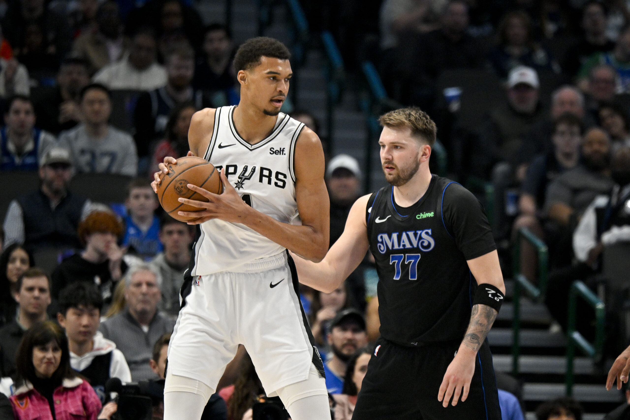 Feb 14, 2024; Dallas, Texas, USA; NBA; San Antonio Spurs center Victor Wembanyama (1) looks to move the ball past Dallas Mavericks guard Luka Doncic (77) during the fist quarter at the American Airlines Center.