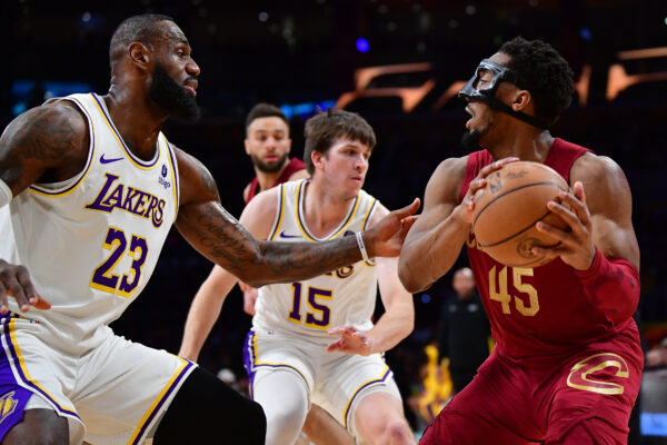 Apr 6, 2024; Los Angeles, California, USA; Cleveland Cavaliers guard Donovan Mitchell (45) controls the ball against Los Angeles Lakers forward LeBron James (23) during the first half at Crypto.com Arena.