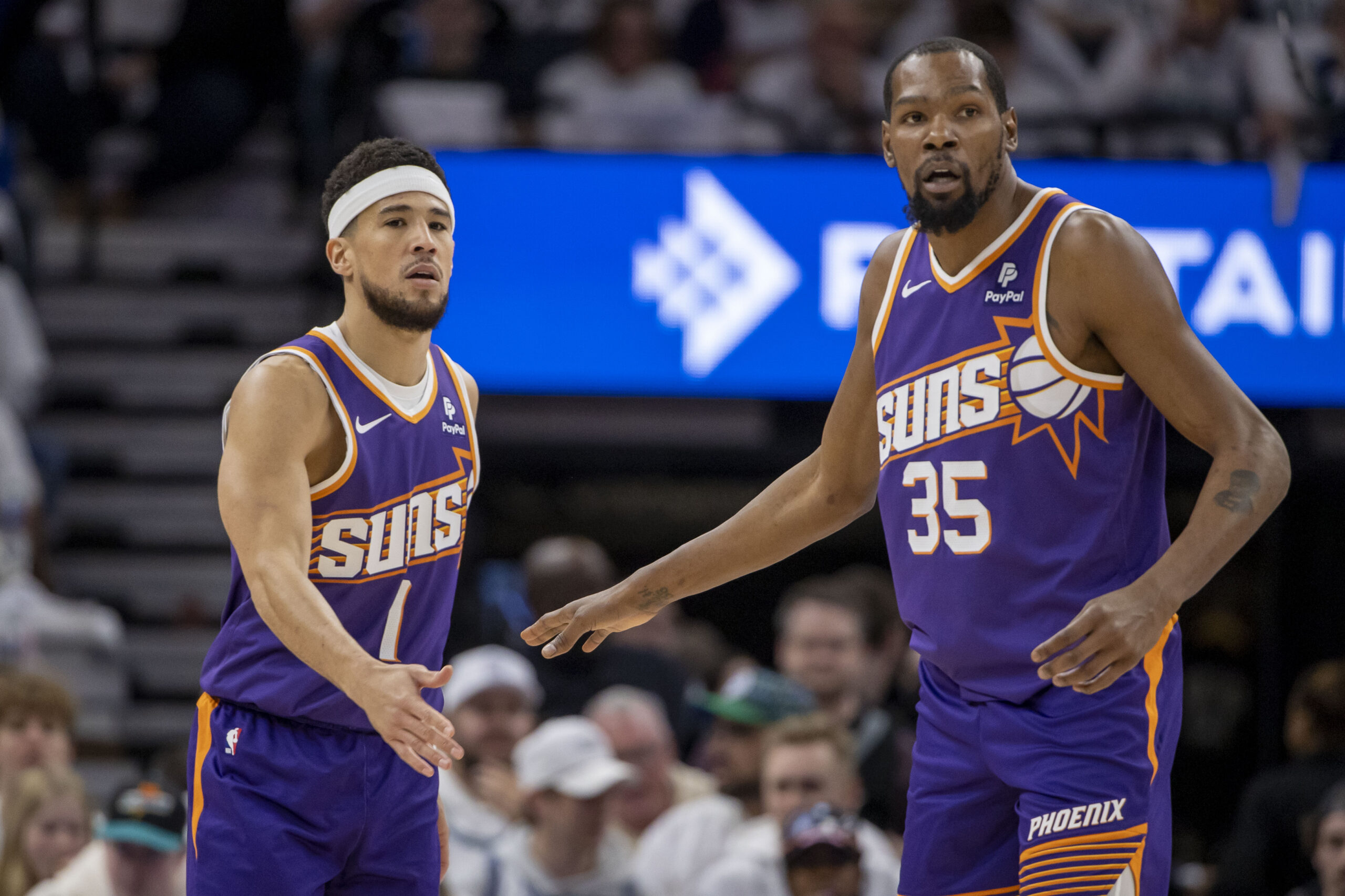 Apr 20, 2024; Minneapolis, Minnesota, USA; Phoenix Suns guard Devin Booker (1) shakes hands with forward Kevin Durant (35) against the Minnesota Timberwolves in the first half during game one of the first round for the 2024 NBA playoffs at Target Center.