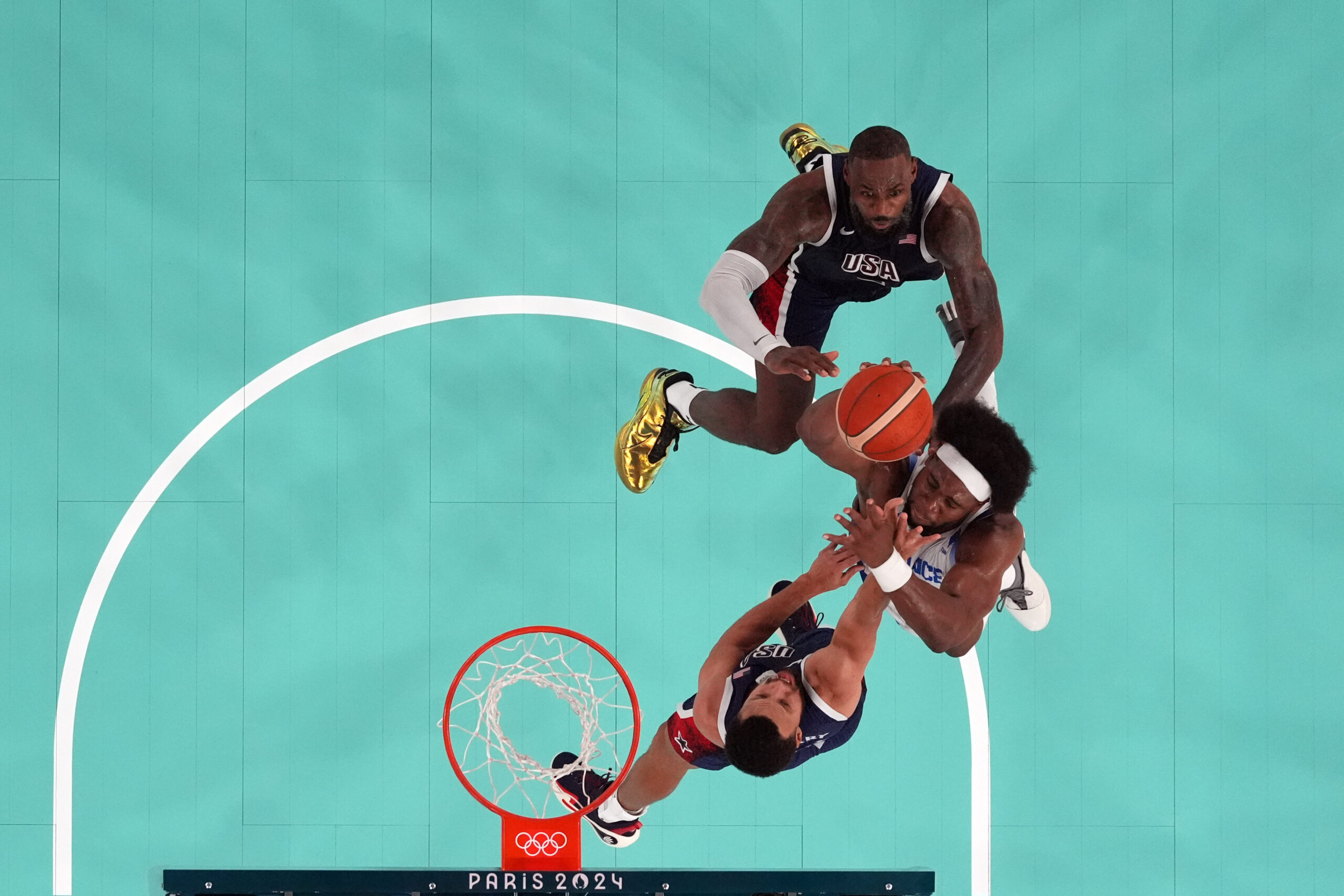 Aug 10, 2024; Paris, France; France power forward Guerschon Yabusele (7) shoots against United States guard LeBron James (6) and shooting guard Stephen Curry (4) in the second half in the men's basketball gold medal game during the Paris 2024 Olympic Summer Games at Accor Arena.