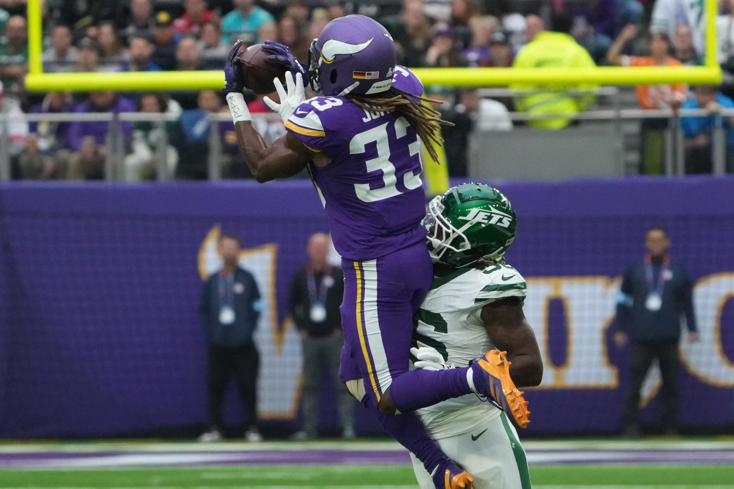 Oct 6, 2024; London, United Kingdom; Minnesota Vikings running back Aaron Jones (33) catches the ball against New York Jets linebacker Quincy Williams (56) in the first half at Tottenham Hotspur Stadium. Mandatory Credit: Kirby Lee-Imagn Images