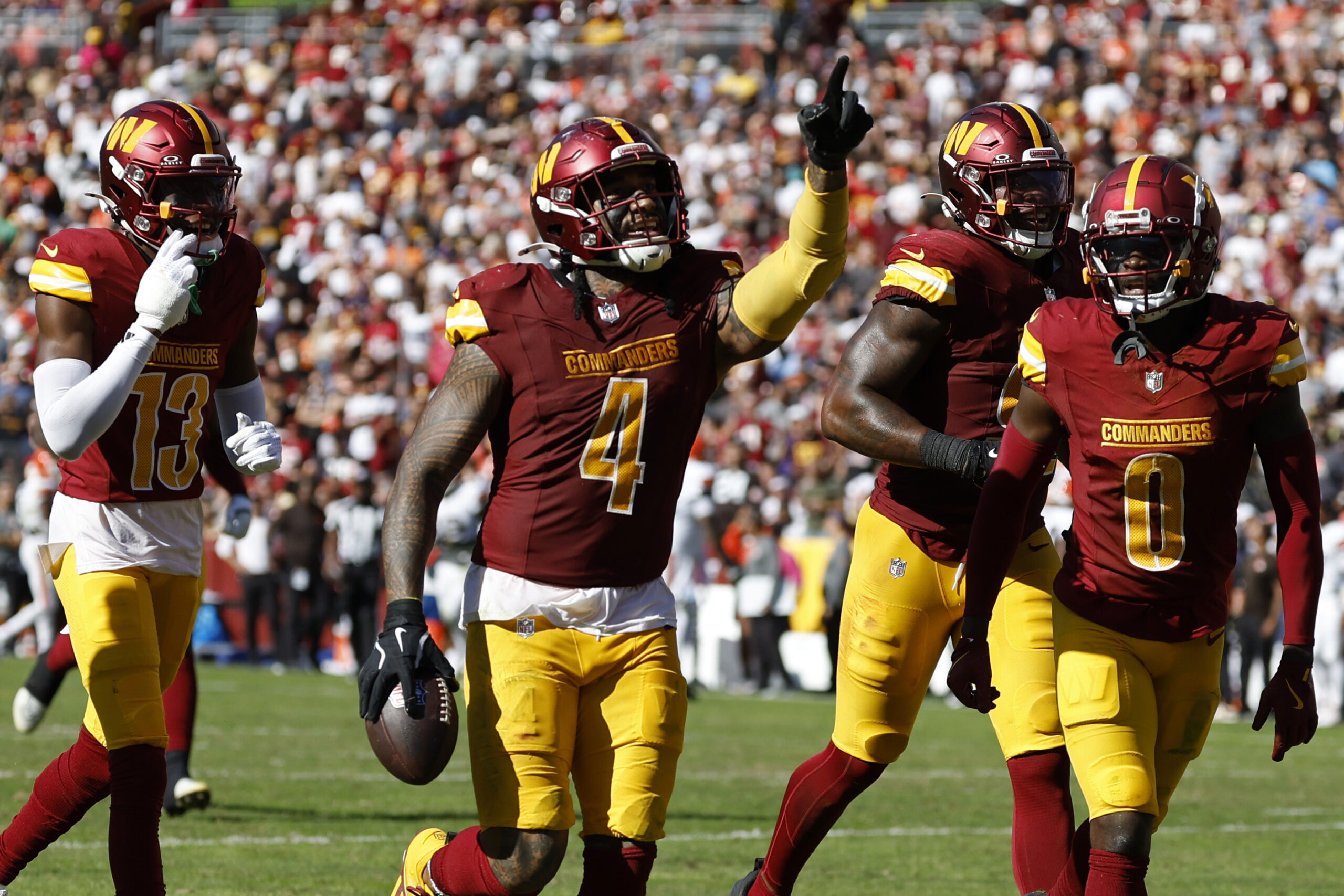 Oct 6, 2024; Landover, Maryland, USA; Washington Commanders linebacker Frankie Luvu (4) celebrates with teammates after recovering a fumble against the Cleveland Browns during the third quarter at NorthWest Stadium.