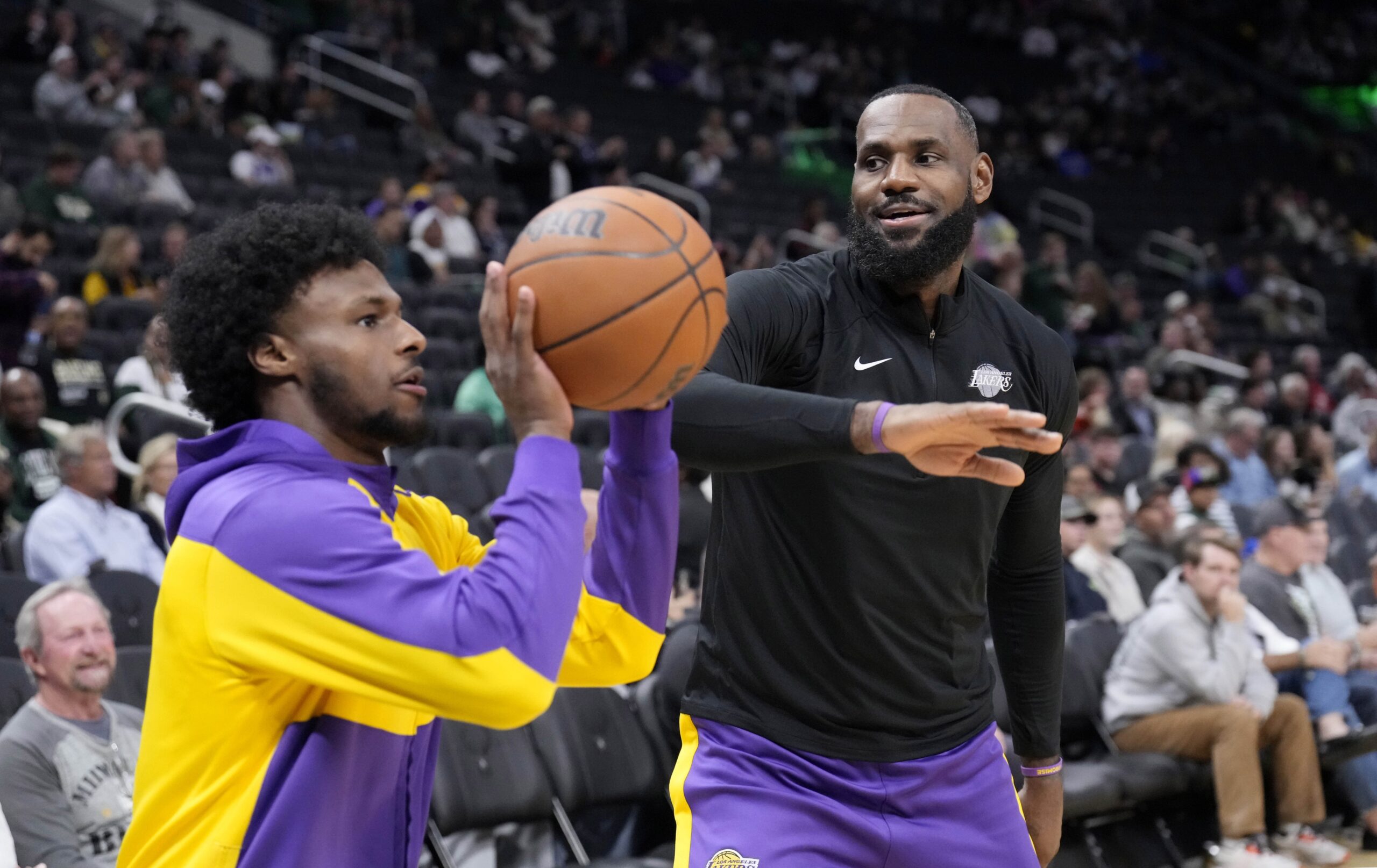 Oct 10, 2024; Milwaukee, Wisconsin, USA; Los Angeles Lakers forward LeBron James (23) goofs around with his son guard Bronny James (9) during warm ups before their game against the Milwaukee Bucks at Fiserv Forum.