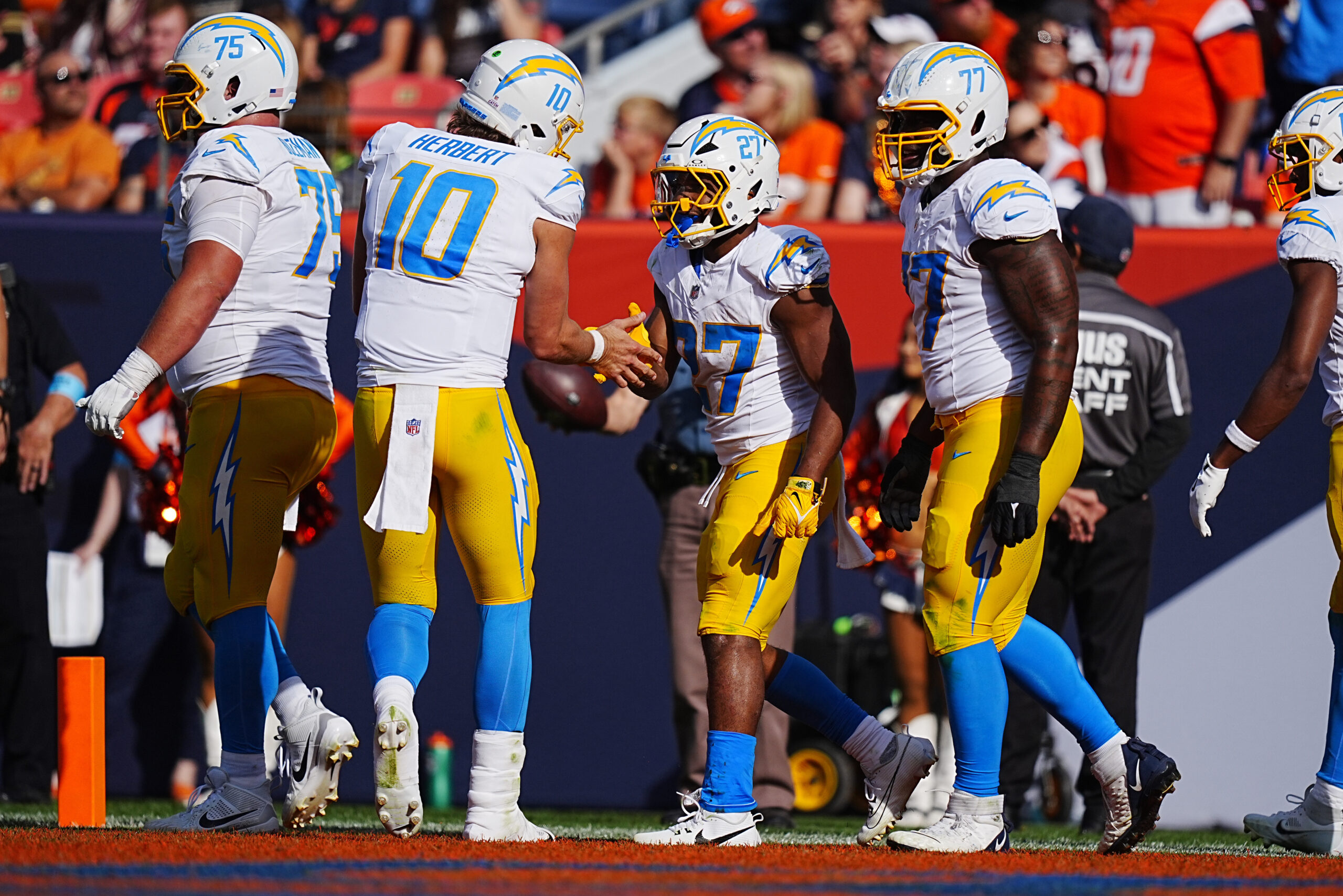 Oct 13, 2024; Denver, Colorado, USA; Los Angeles Chargers running back J.K. Dobbins (27) celebrates his touchdown carry with quarterback Justin Herbert (10) in the second quarter against the Denver Broncos at Empower Field at Mile High.