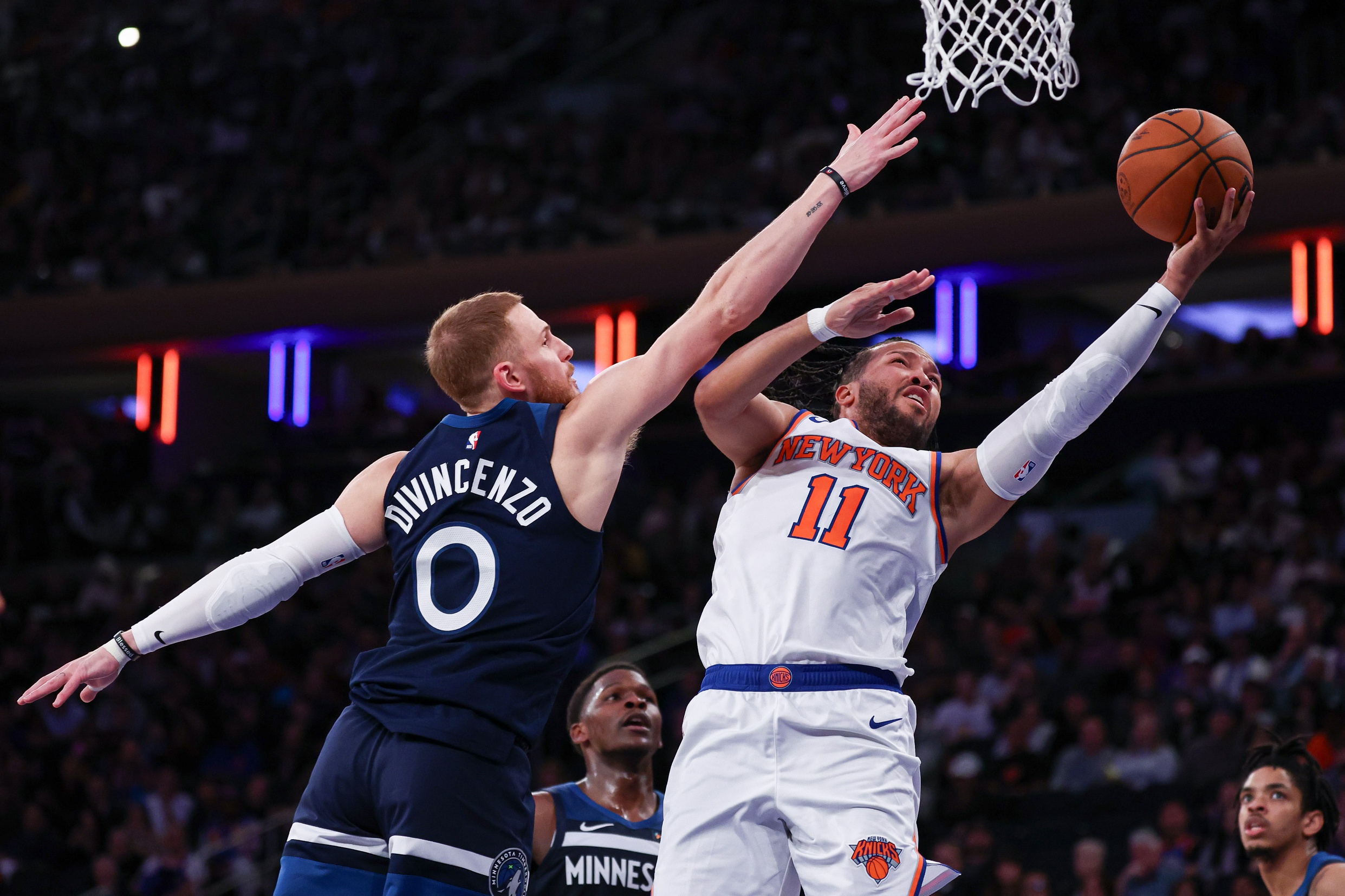 Oct 13, 2024; New York, New York, USA; New York Knicks guard Jalen Brunson (11) drives to the basket as Minnesota Timberwolves guard Donte DiVincenzo (0) defends during the first half at Madison Square Garden. Mandatory Credit: Vincent Carchietta-Imagn Images