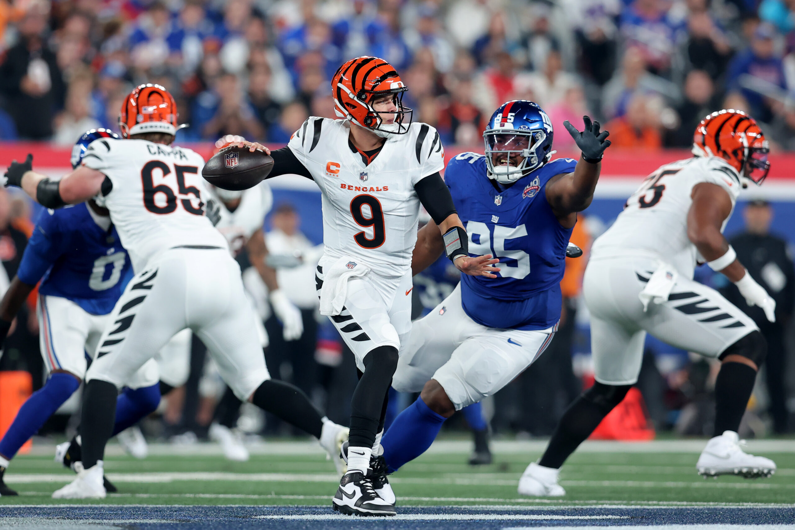 NFL: Cincinnati Bengals at New York Giants. Oct 13, 2024; East Rutherford, New Jersey, USA; Cincinnati Bengals quarterback Joe Burrow (9) looks to pass against New York Giants defensive tackle Jordon Riley (95) during the first quarter at MetLife Stadium. Mandatory Credit: Brad Penner-Imagn Images