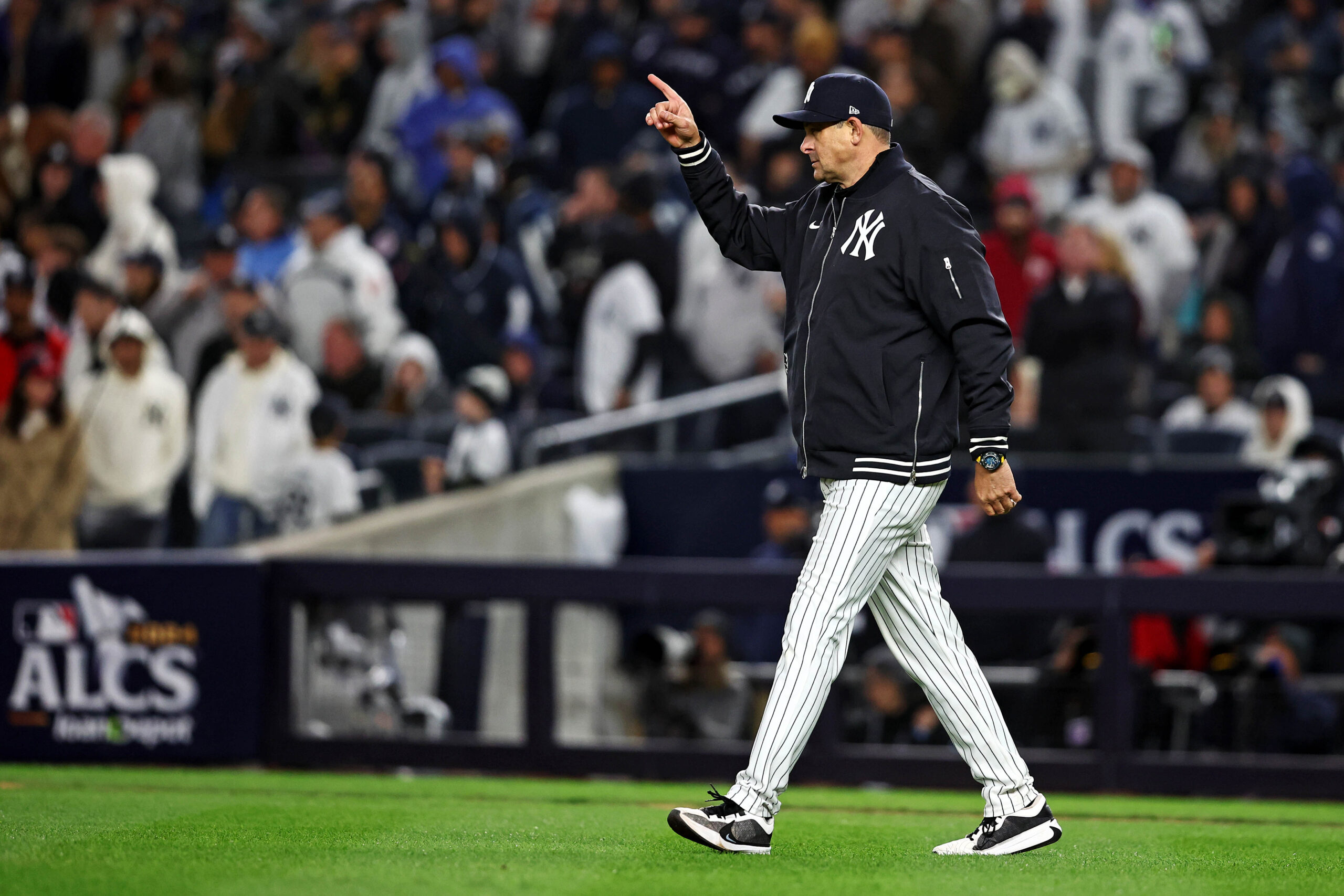 Oct 14, 2024; Bronx, New York, USA; New York Yankees manger Aaron Boone signals to the bull pen for a pitching change eighth inning against the Cleveland Guardiansin game one of the ALCS for the 2024 MLB Playoffs at Yankee Stadium. Mandatory Credit: Wendell Cruz-Imagn Images