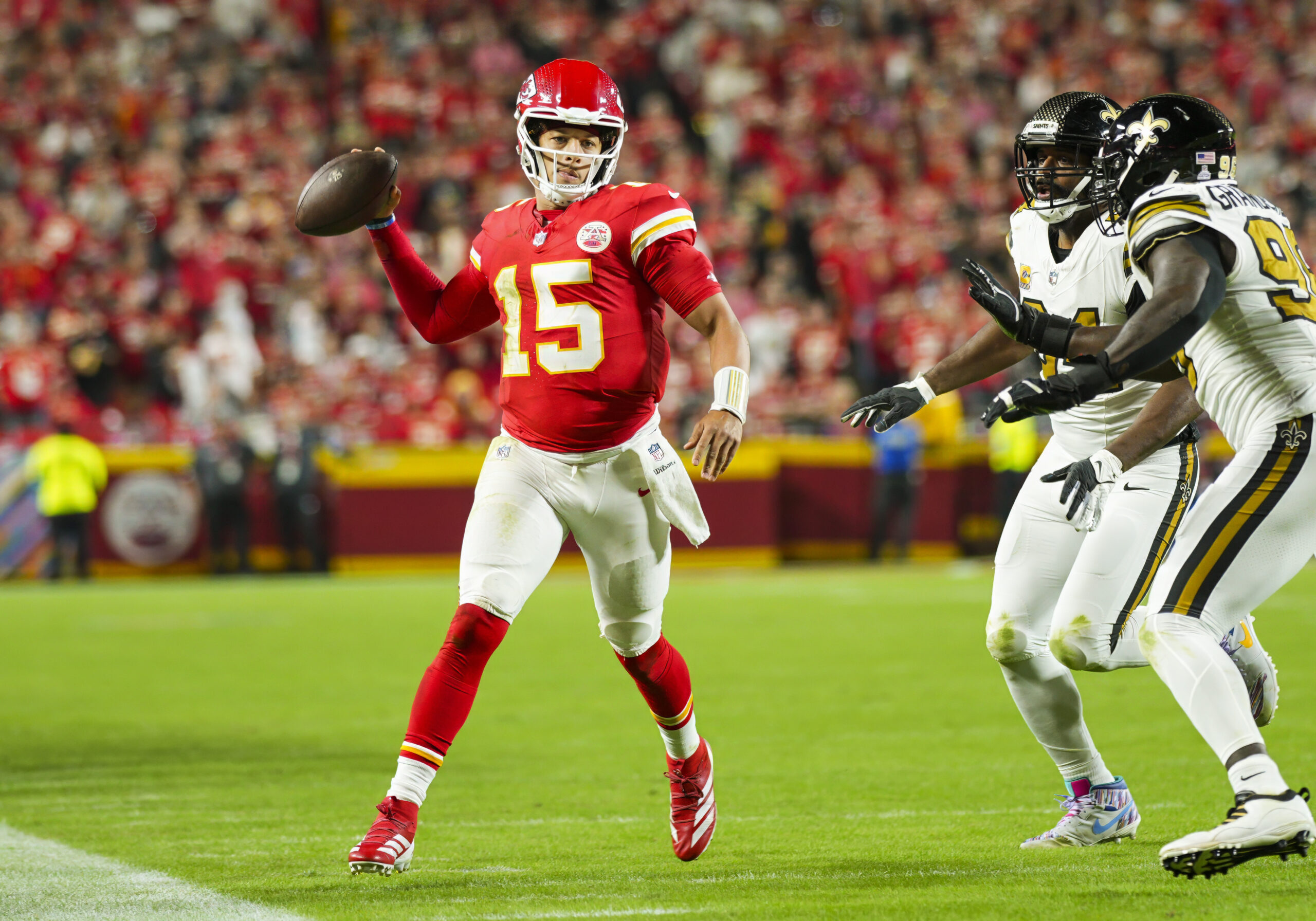 Oct 7, 2024; Kansas City, Missouri, USA; Kansas City Chiefs quarterback Patrick Mahomes (15) throws a pass against New Orleans Saints defensive end Cameron Jordan (94) and defensive end Carl Granderson (96) during the first half at GEHA Field at Arrowhead Stadium. Mandatory Credit: Jay Biggerstaff-Imagn Images