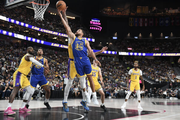 Oct 15, 2024; Las Vegas, Nevada, USA; Golden State Warriors guard Stephen Curry (30) is blocked by Los Angeles Lakers forward Anthony Davis (3) in the second quarter at T-Mobile Arena.