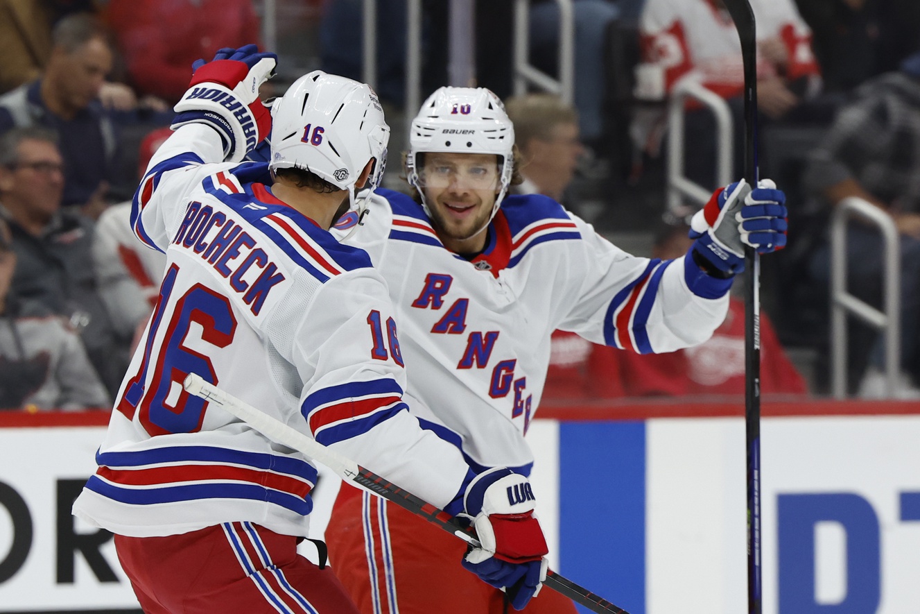 Oct 17, 2024; Detroit, Michigan, USA; New York Rangers left wing Artemi Panarin (10) receives congratulations from teammates after scoring in the first period against the Detroit Red Wings at Little Caesars Arena. Mandatory Credit: Rick Osentoski-Imagn Images