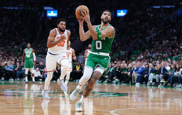 Oct 22, 2024; Boston, Massachusetts, USA; Boston Celtics forward Jayson Tatum (0) returns the ball to score against New York Knicks center Karl-Anthony Towns (32) in the first quarter at TD Garden.