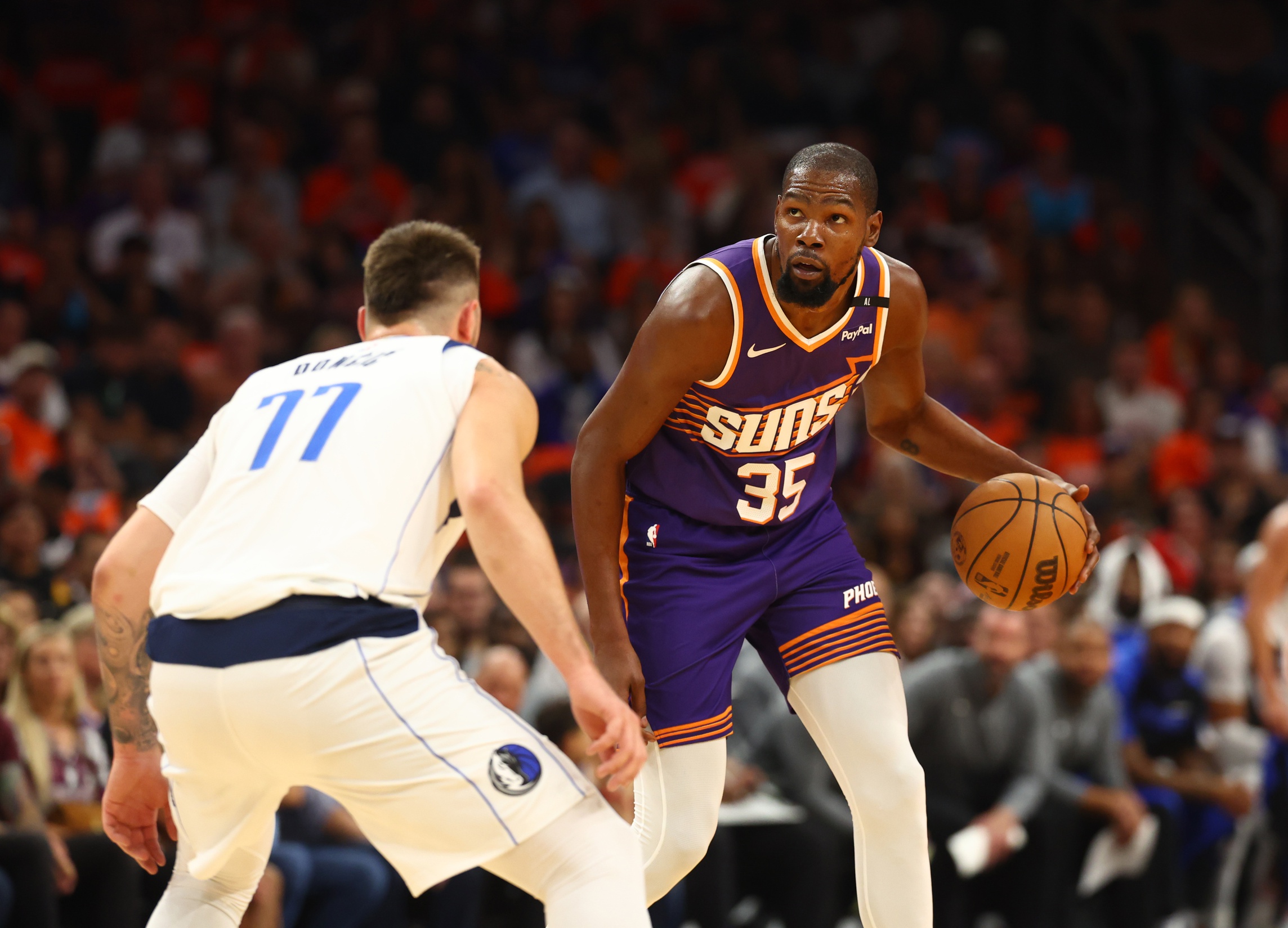 Oct 26, 2024; Phoenix, Arizona, USA; Phoenix Suns forward Kevin Durant (35) moves the ball against Dallas Mavericks guard Luka Doncic (77) in the first half of the home opener at Footprint Center.