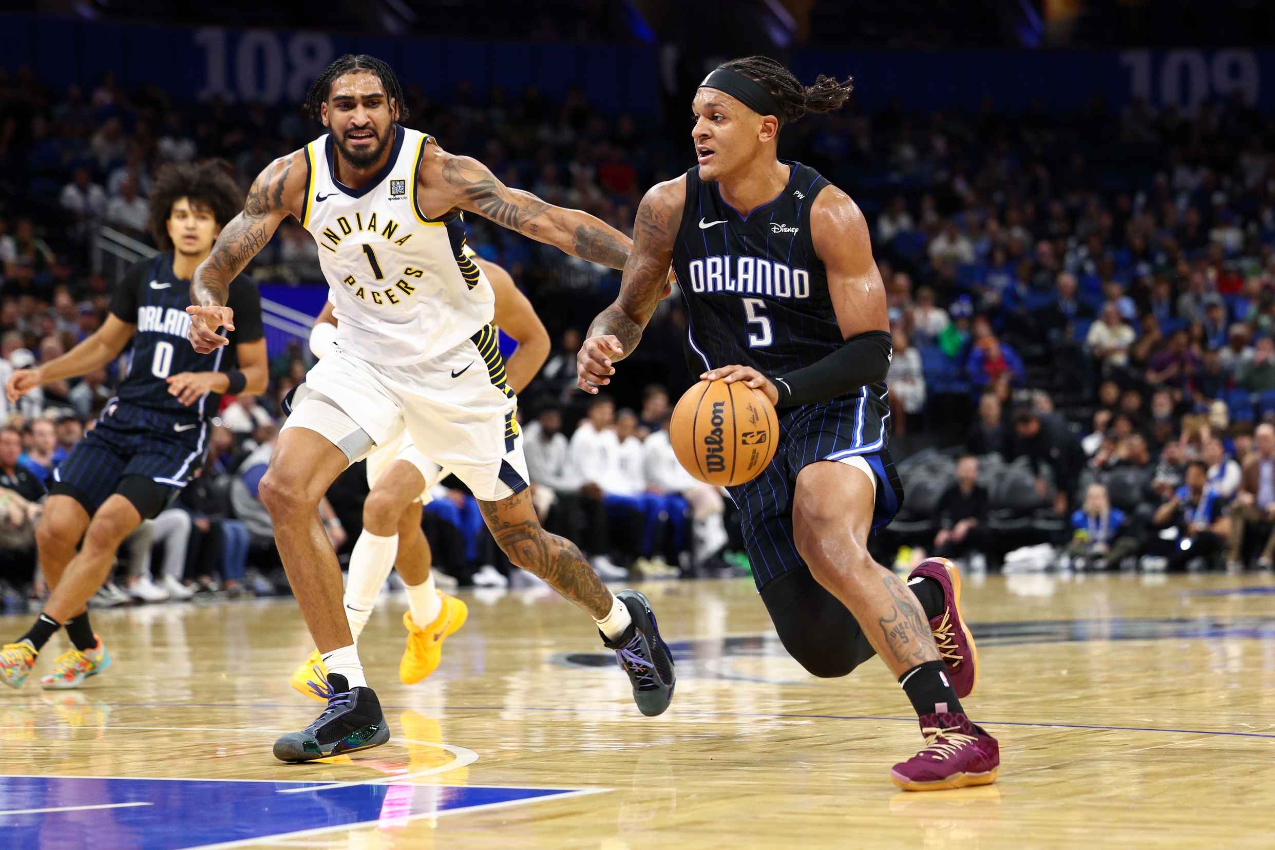 Oct 28, 2024; Orlando, Florida, USA; Orlando Magic forward Paolo Banchero (5) drives to the hoop past Indiana Pacers forward Obi Toppin (1) in the first quarter at Kia Center. Mandatory Credit: Nathan Ray Seebeck-Imagn Images