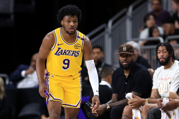 PALM SPRINGS, CALIFORNIA - OCTOBER 04: LeBron James #23 watches the game from the bench as Bronny James #9 of the Los Angeles Lakers looks on during the second half of a game against the Minnesota Timberwolves at Acrisure Arena on October 04, 2024 in Palm Springs, California.