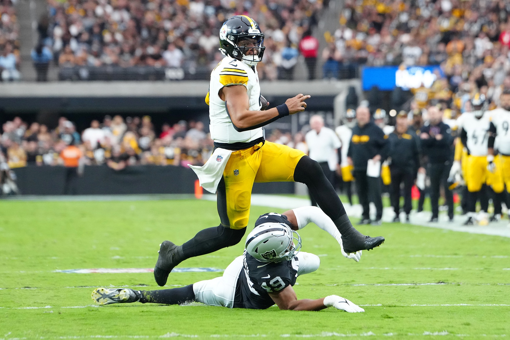 Oct 13, 2024; Paradise, Nevada, USA; Pittsburgh Steelers quarterback Justin Fields (2) evades the tackle attempt of Las Vegas Raiders defensive end Charles Snowden (49) during the second quarter at Allegiant Stadium.